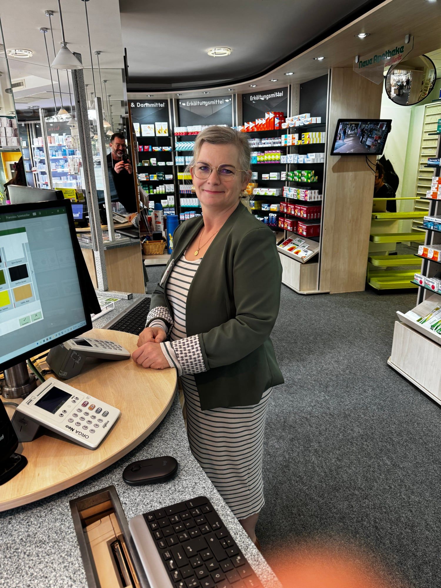 Mitarbeiterin der Neuen Apotheke am Markt am Beratungstisch im Verkaufsraum